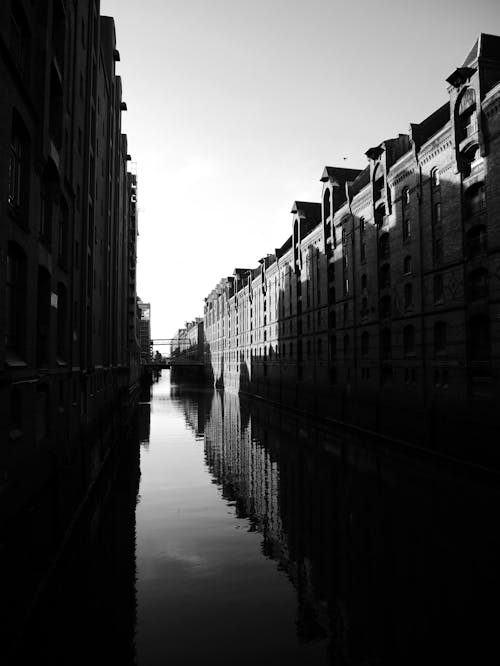 Free Grayscale Photograph of a River Between Buildings Stock Photo