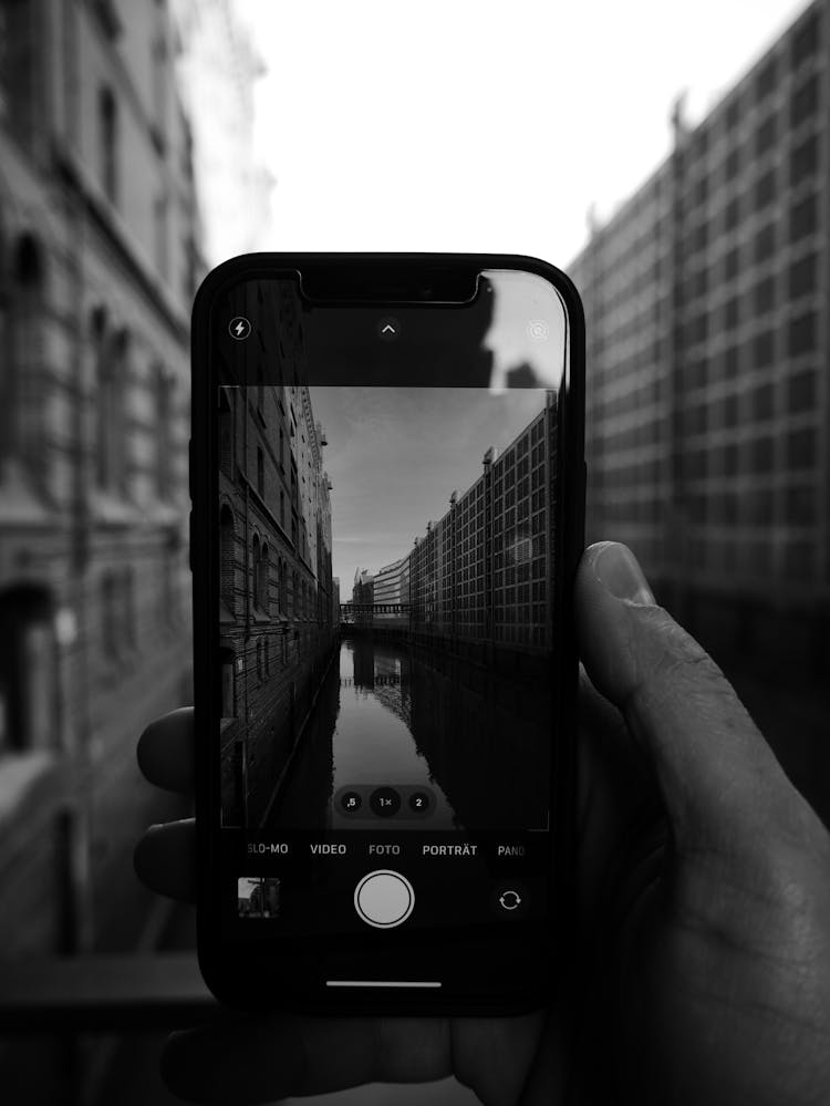 Hand Holding Black Smartphone With Image On Screen