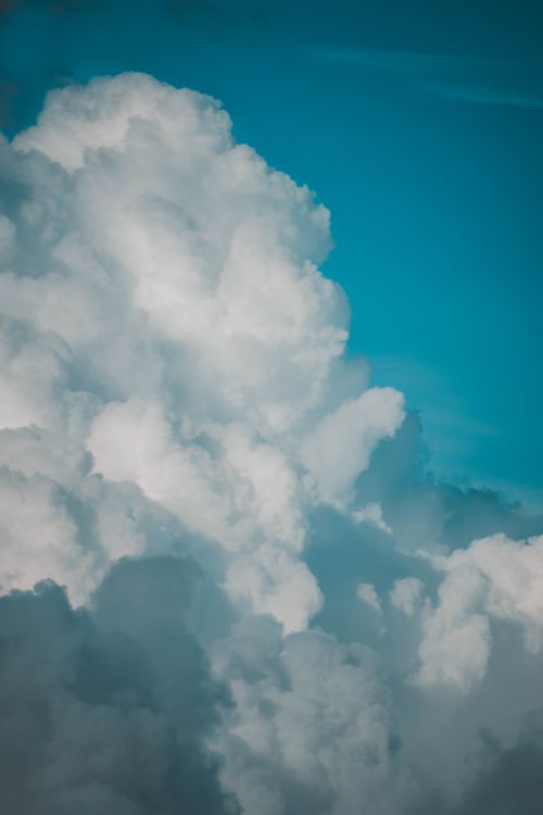 Free A stunning view of fluffy cumulus clouds set against a vibrant blue sky, capturing the beauty of nature. Stock Photo
