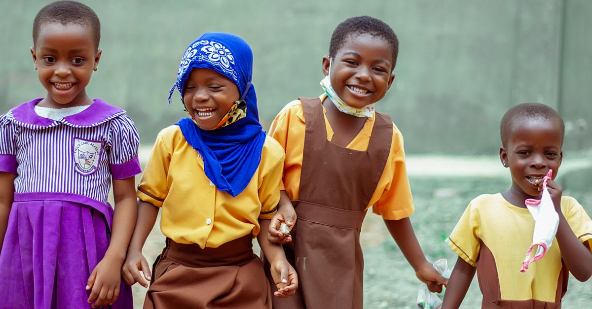 families walking into a modern church building in Ho Ghana with children laughing