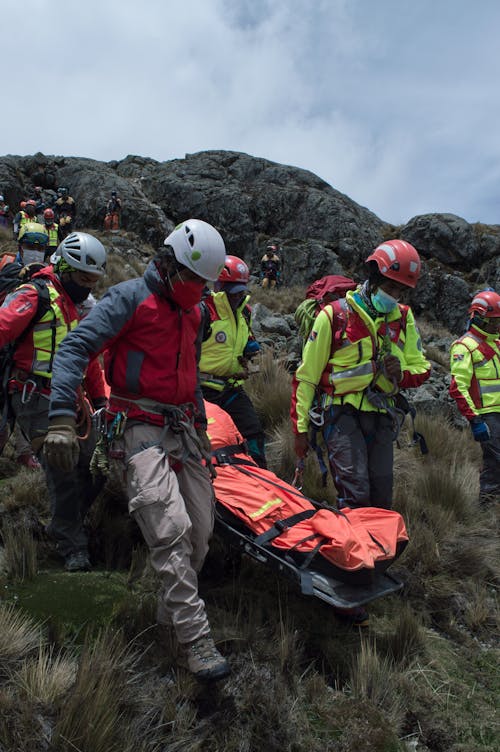 Free Rescue Team Saving an Injured Person on Mountainside Stock Photo