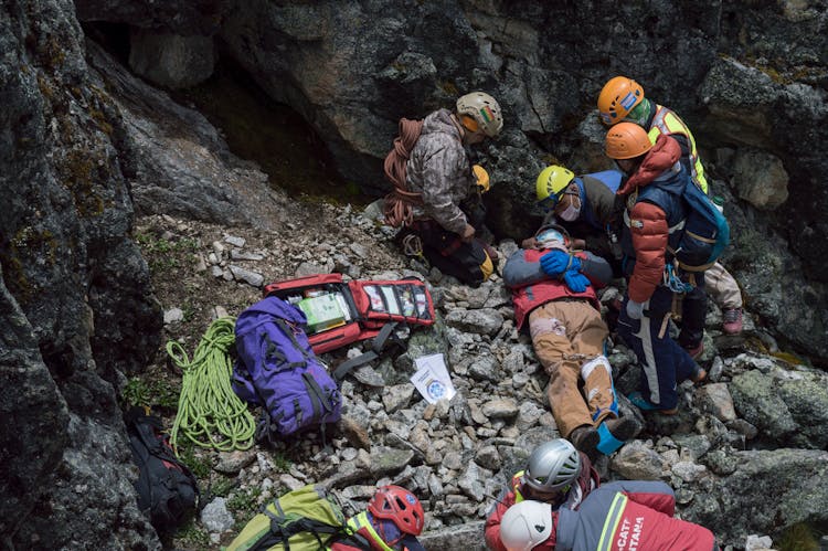 Rescue Team Saving An Injured Person On Rocky Mountainside