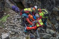 Group of Rescue Men Saving an Injured Person on Rocky Mountainside