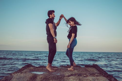 Free A happy couple enjoying a romantic dance on the beach at sunset. Stock Photo