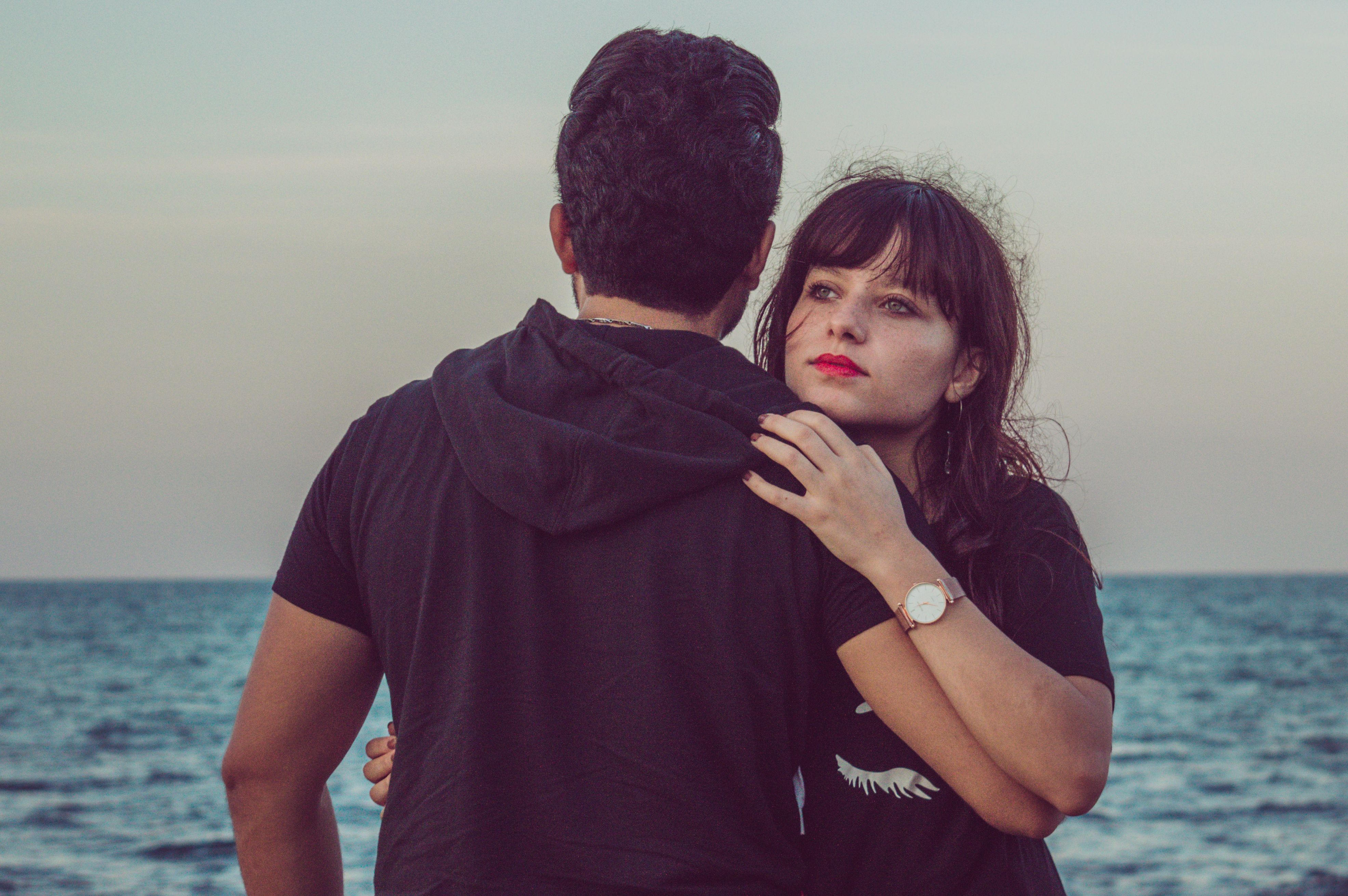 A romantic couple embraces by the ocean, capturing a moment of love and connection.