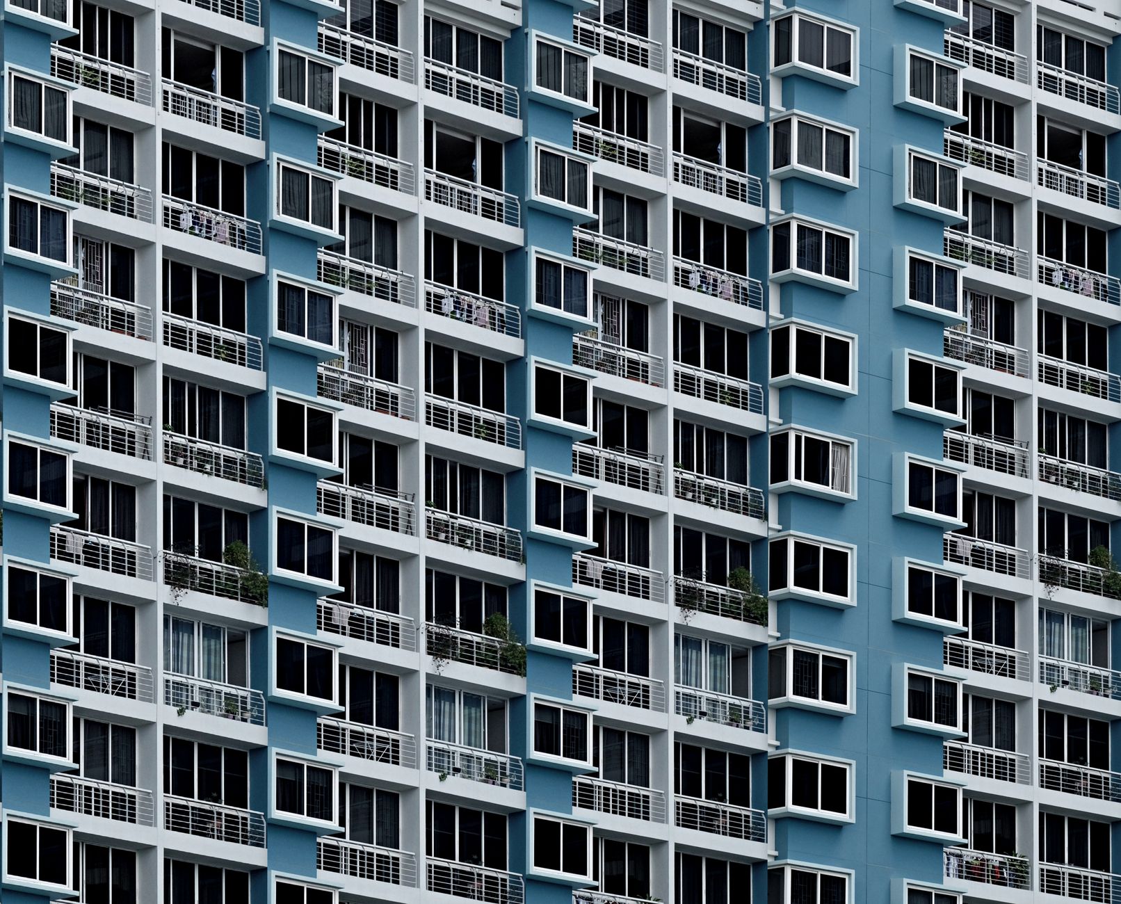 High-rise building facade with repetitive geometric window patterns in Singapore.