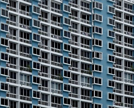High-rise building facade with repetitive geometric window patterns in Singapore.