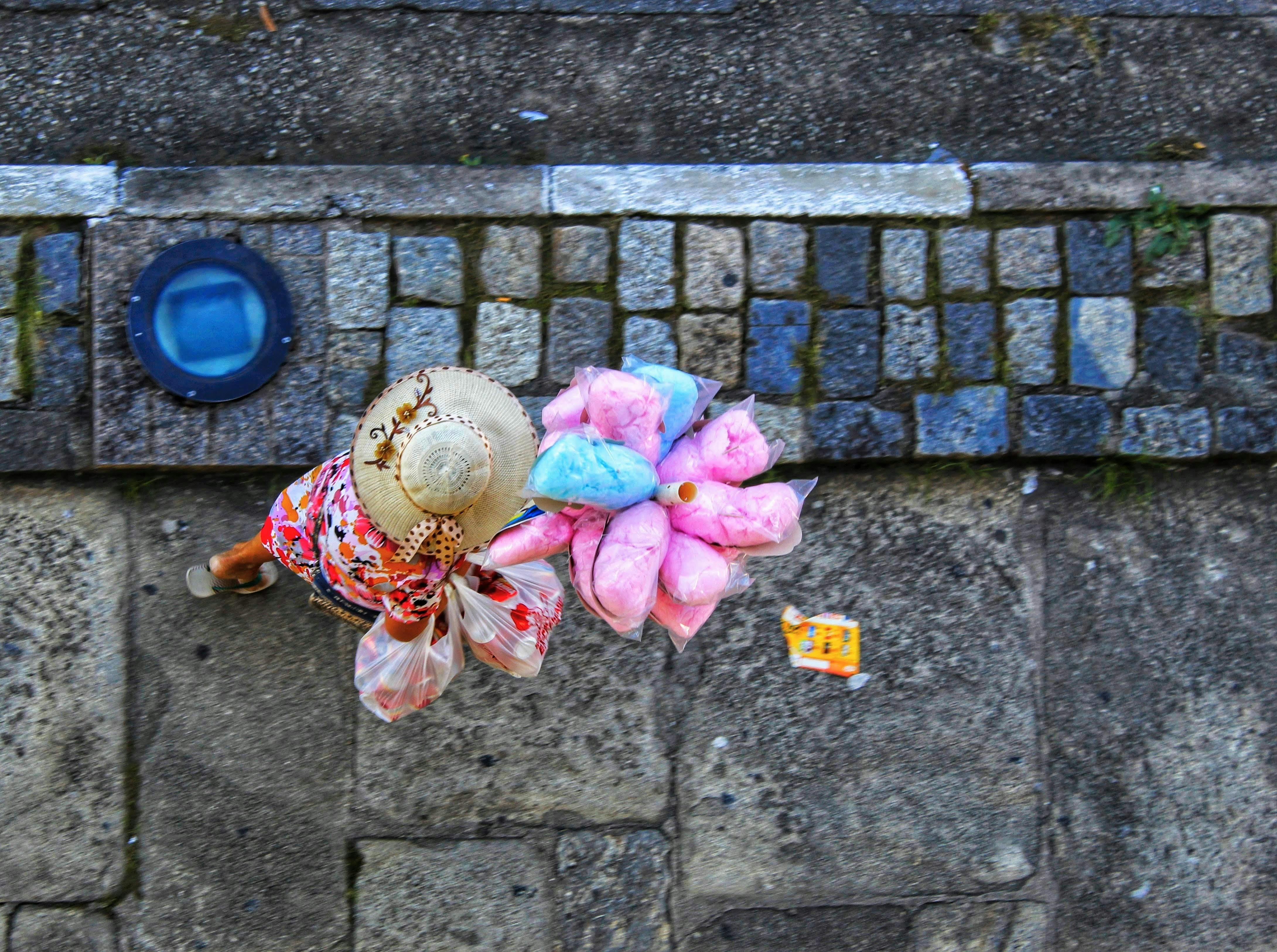 Aerial view of a street vendor in Brazil selling pink and blue cotton candy.