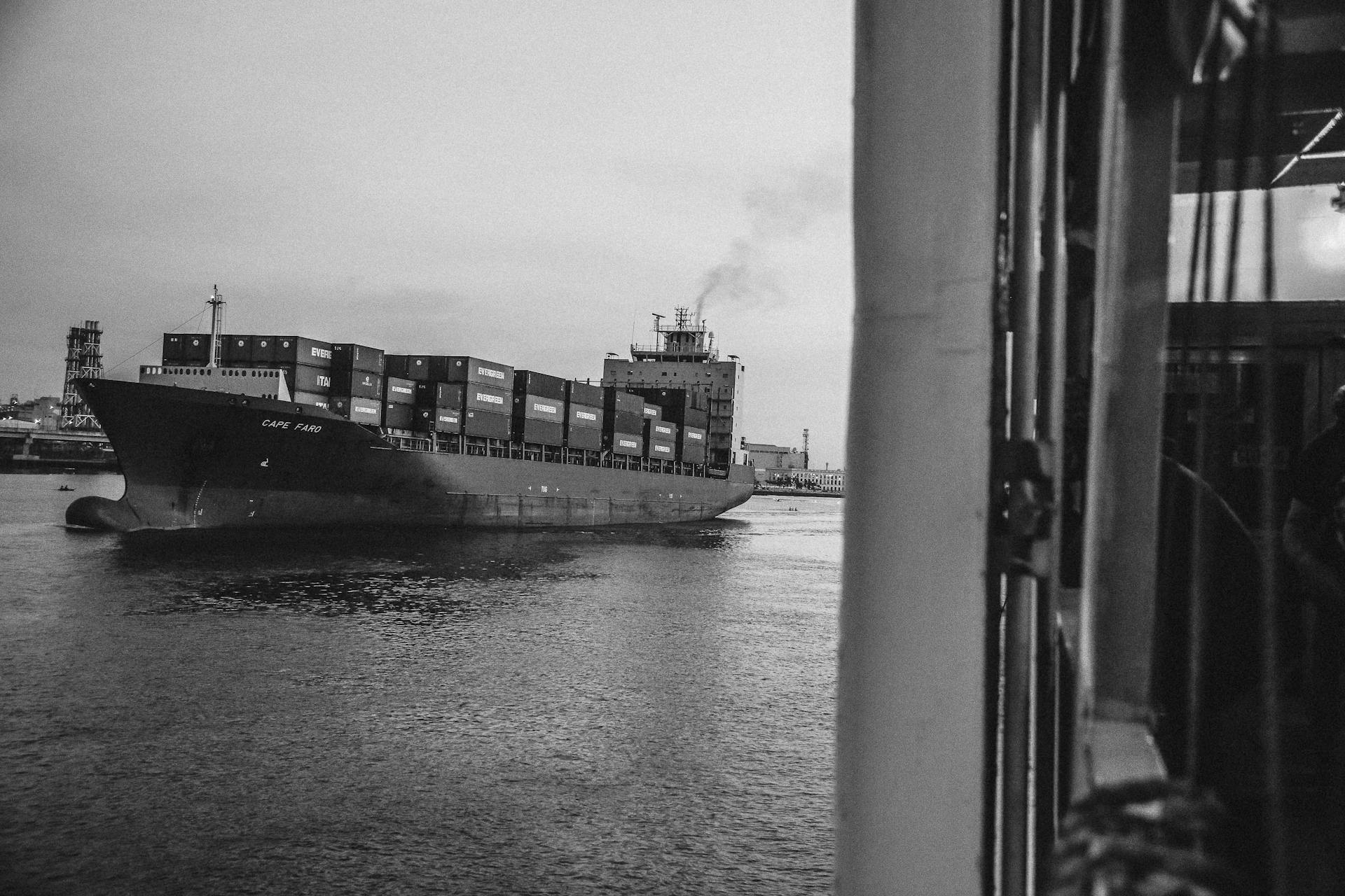 Greyscale Photo of Cargo Ship on Ocean