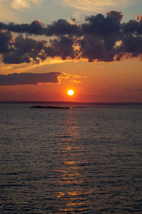 Free Capture of a breathtaking ocean sunset with dramatic clouds and vibrant colors. Stock Photo