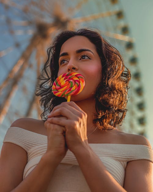 Woman Holding a Lollipop Near Her Face