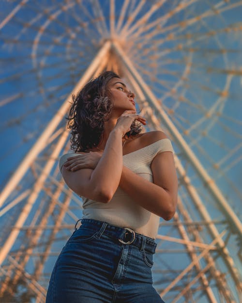 Woman Standing Near a Ferris Wheel