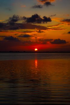 Dramatic sunset over the ocean in Cancún, capturing golden hour hues and silhouettes.