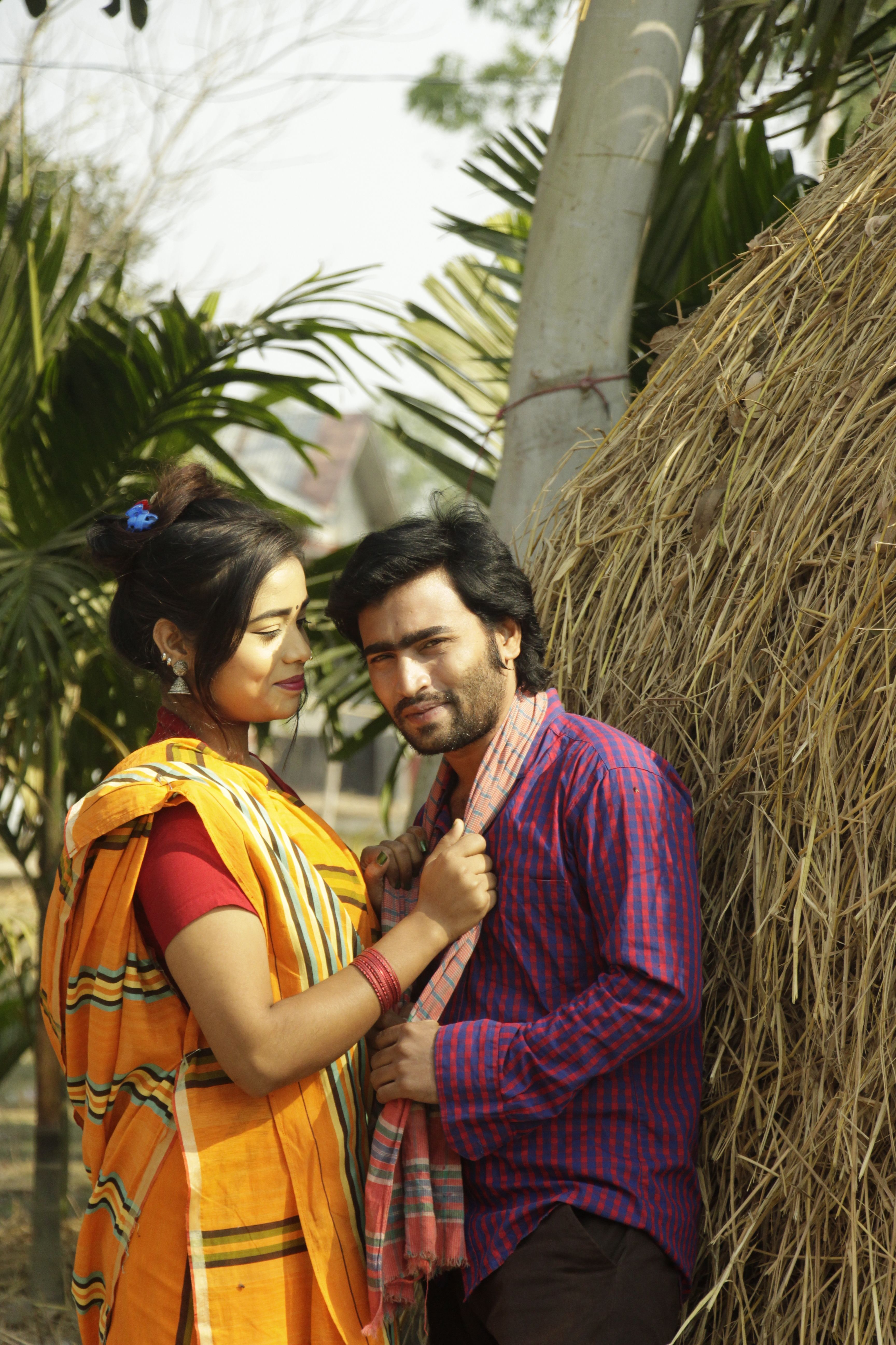 Young couple in traditional clothing enjoying a warm outdoor setting, showcasing cultural heritage.