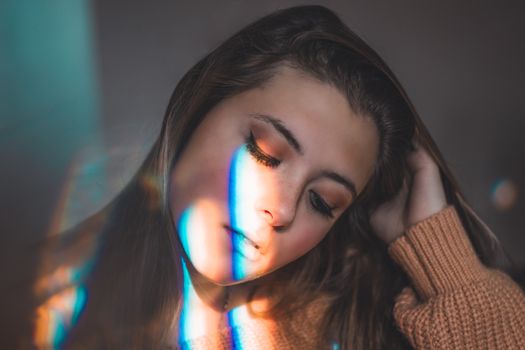 A serene portrait of a woman with colorful light effects on her face.