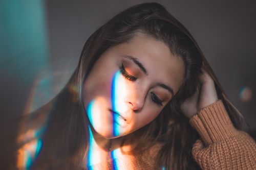 Free A serene portrait of a woman with colorful light effects on her face. Stock Photo