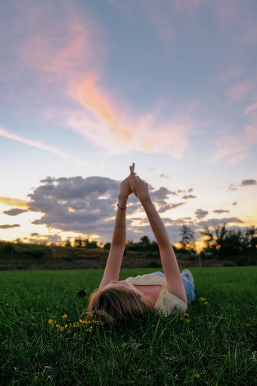 Woman  Lying on Green Grass Under Blue Sky