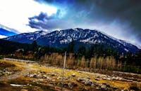 美丽的雪山、多云的天空和岩石地形构成了一幅壮丽的景观