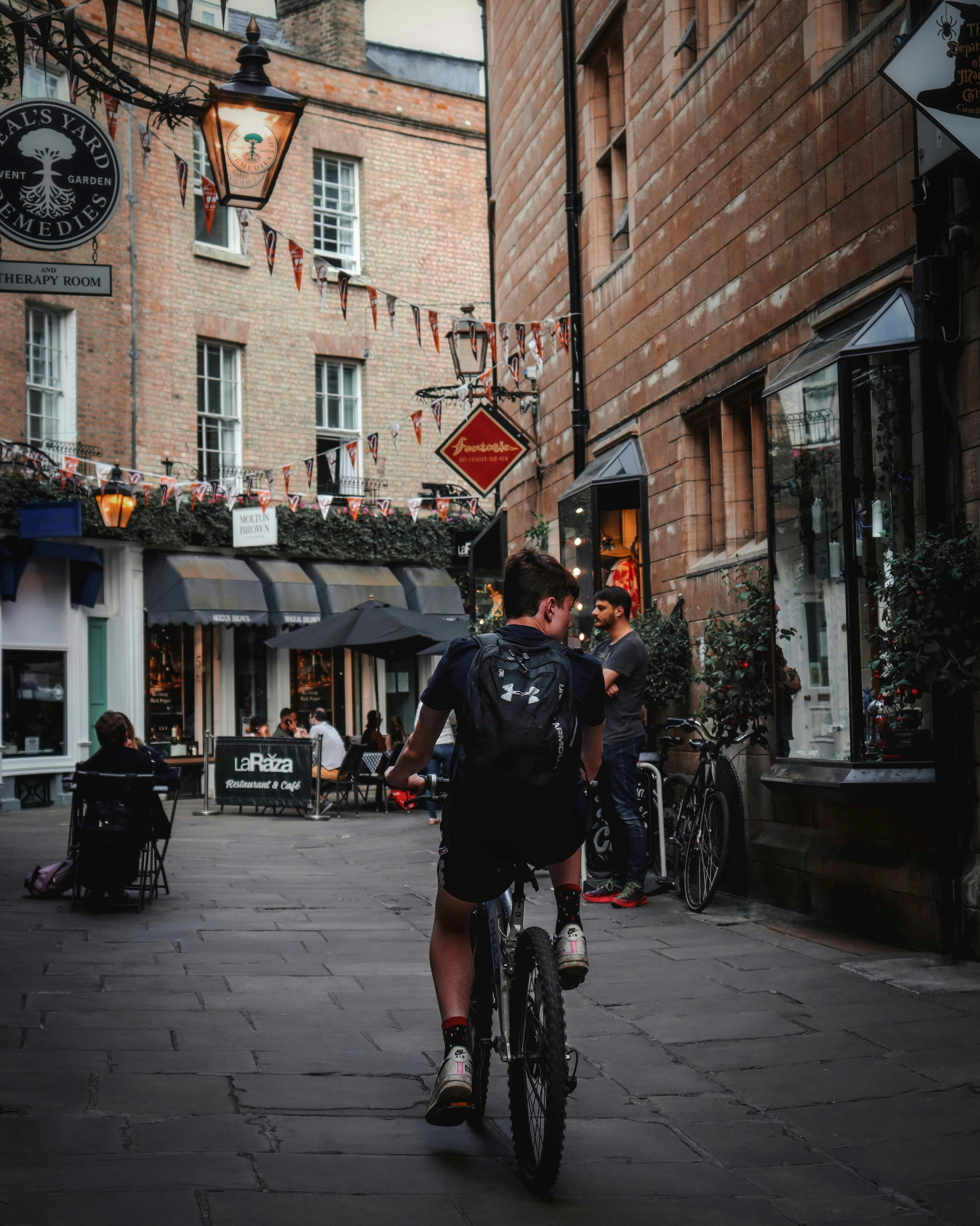 A Side View of a Man Riding a Bicycle on the Street · Free Stock Photo