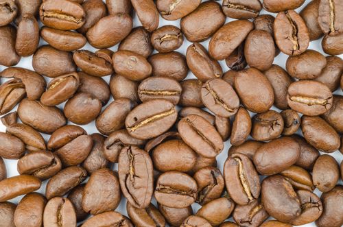 Free A detailed close-up of fresh roasted coffee beans showcasing their rich texture and color. Stock Photo