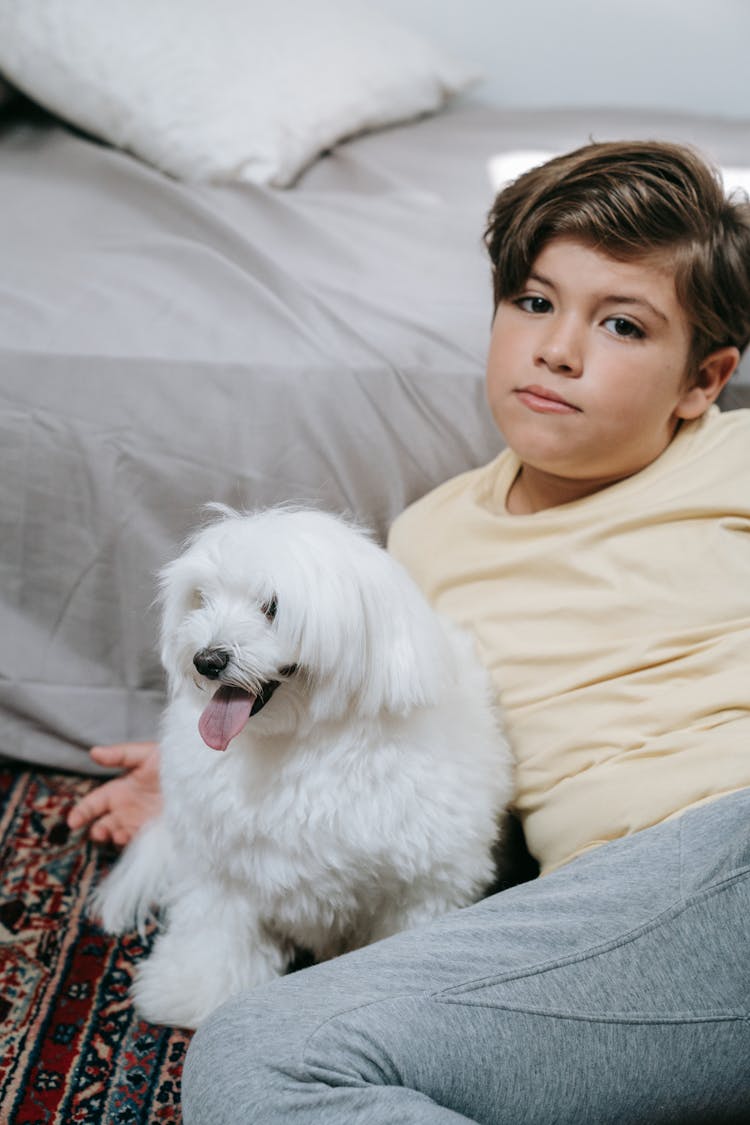 A Boy And A Dog Sitting On The Floor