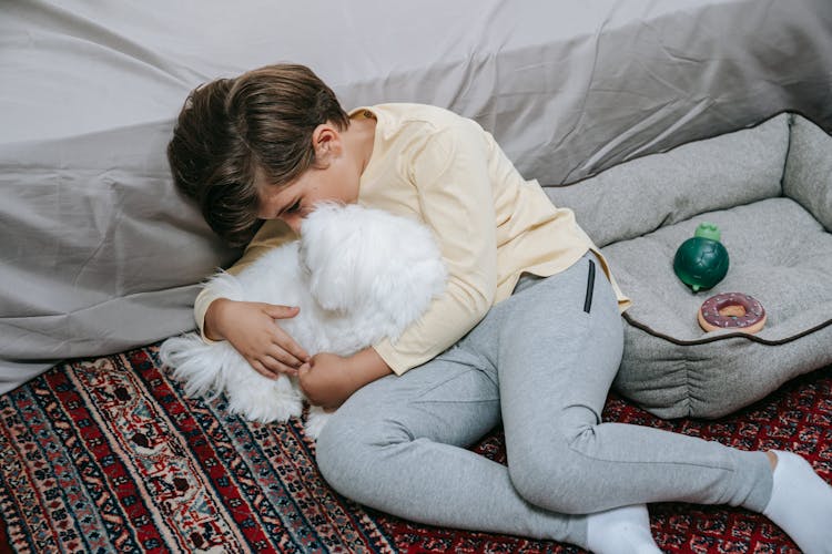 A Boy Cuddling With His Dog