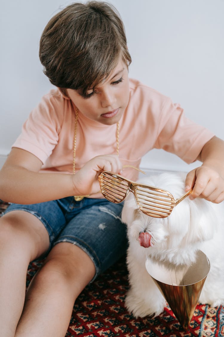 A Boy Putting Shutter Shades On His Pet