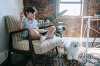 Woman in Gray and Black Stripe Shirt Sitting on Brown Wooden Armchair
