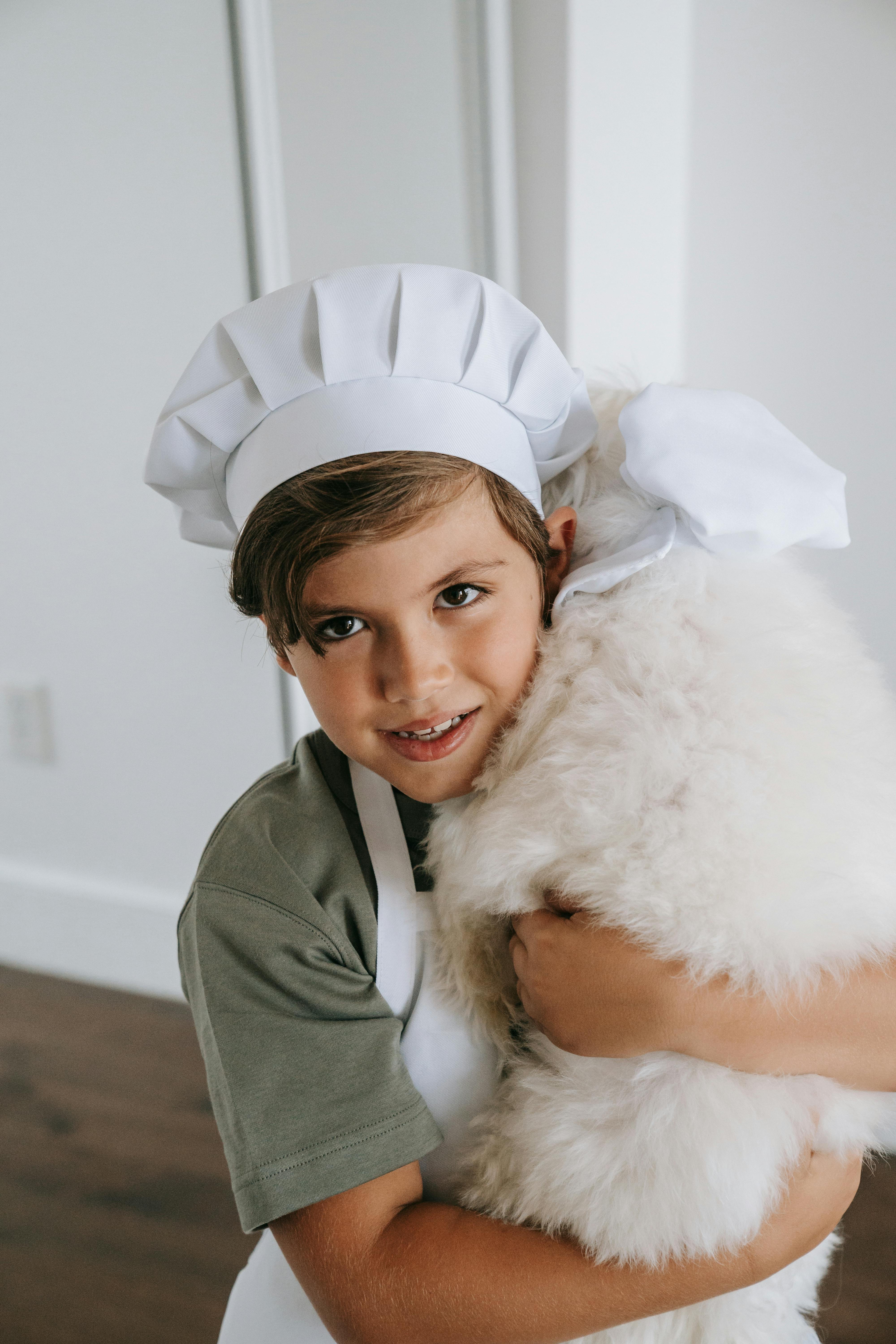 A Boy Wearing a Toque Carrying His Dog · Free Stock Photo