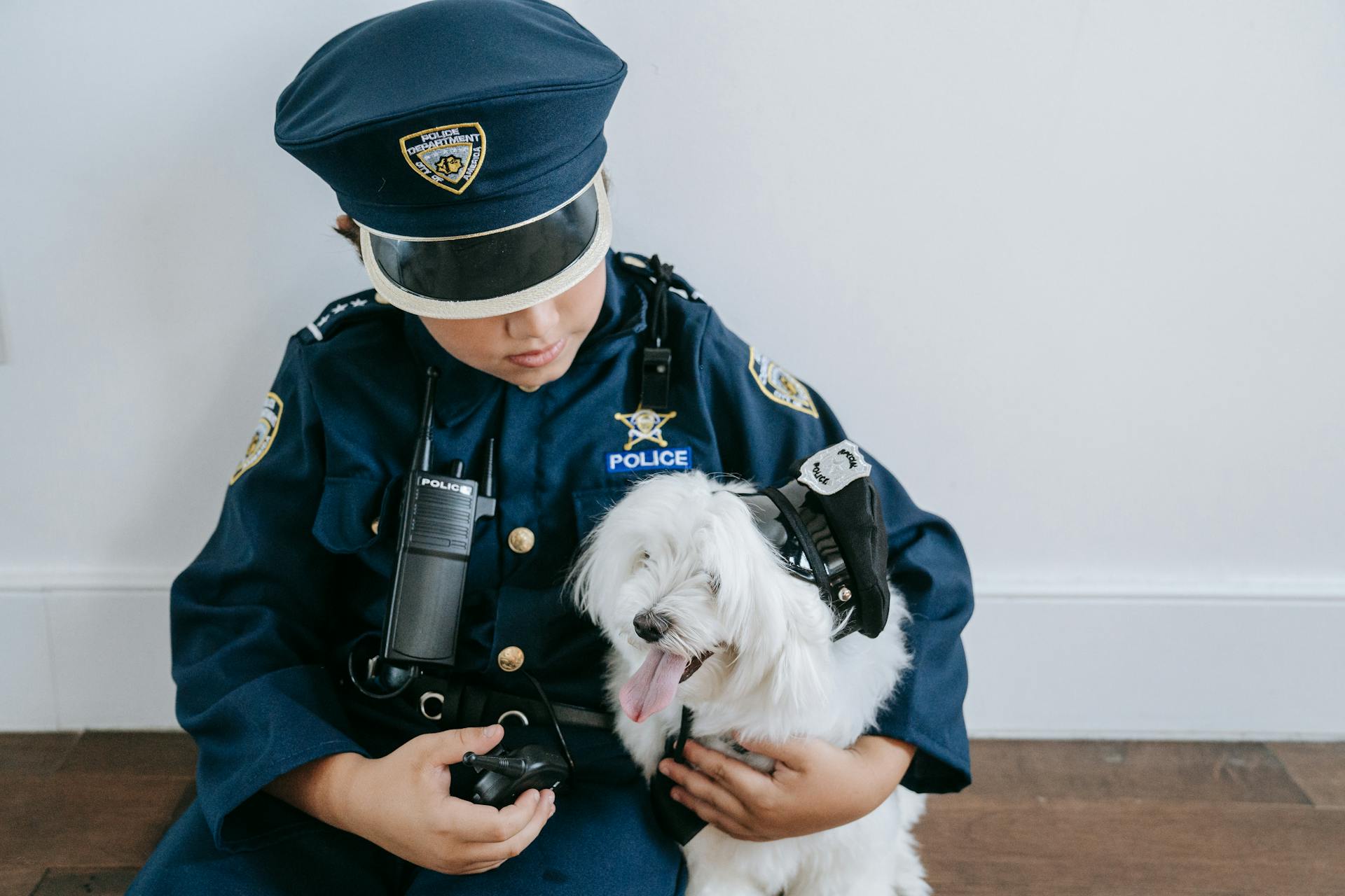 Un garçon en costume de policier tenant un chien