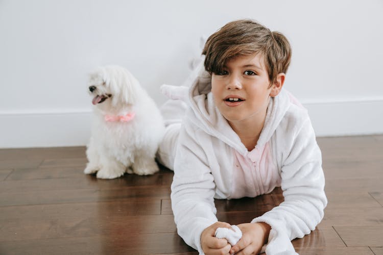 Boy In White Hoodie Sitting On Brown Wooden Floor