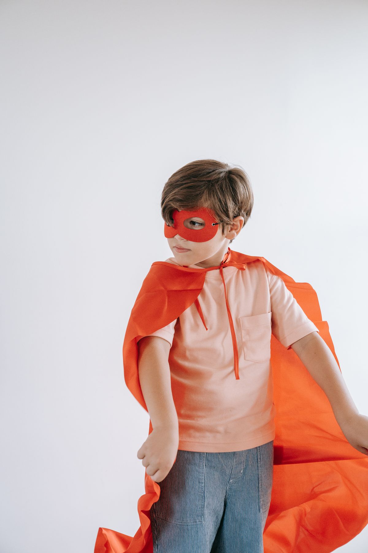 Boy in a red cape and a superhero mask