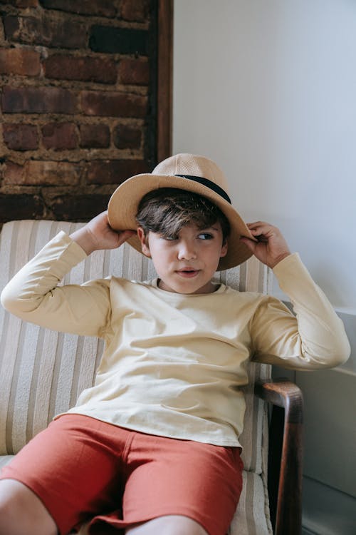 Boy Wearing Hat Sitting on a Chair