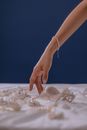 Person in Gold Bracelet Holding White Sand