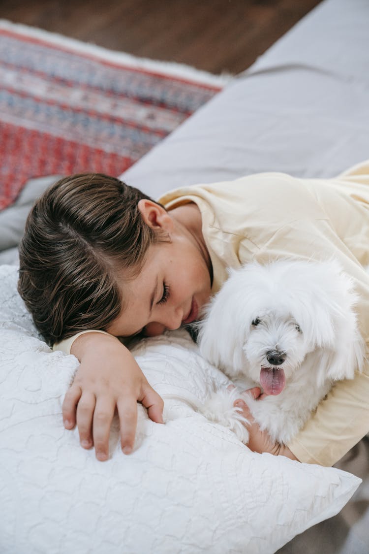 Kid Lying On Bed With His Dog