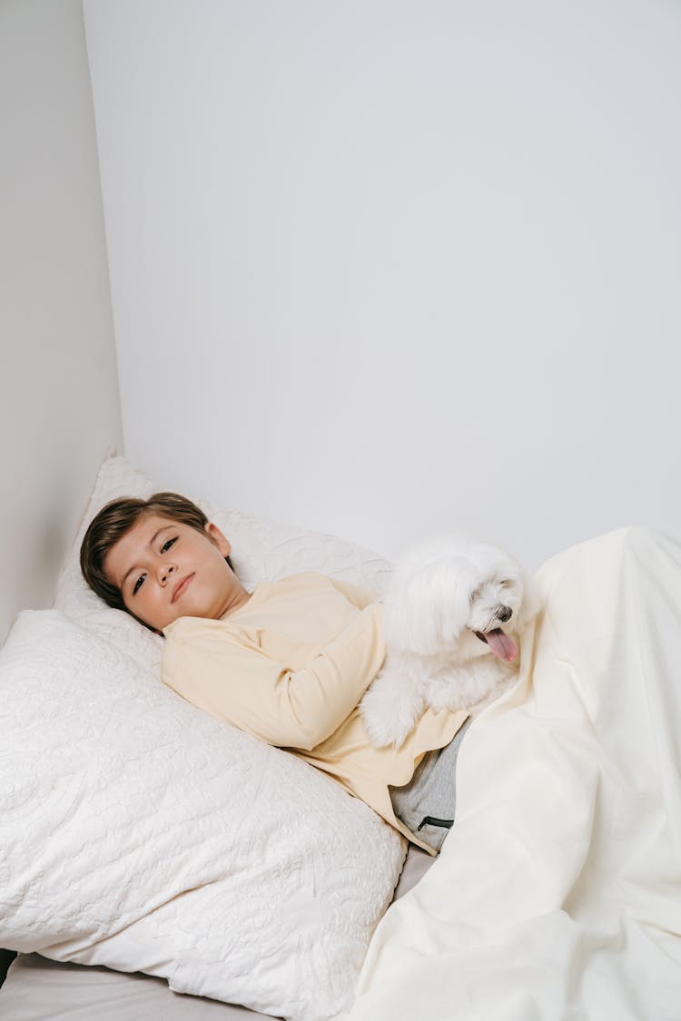 Boy Lying On Blanket With A Dog