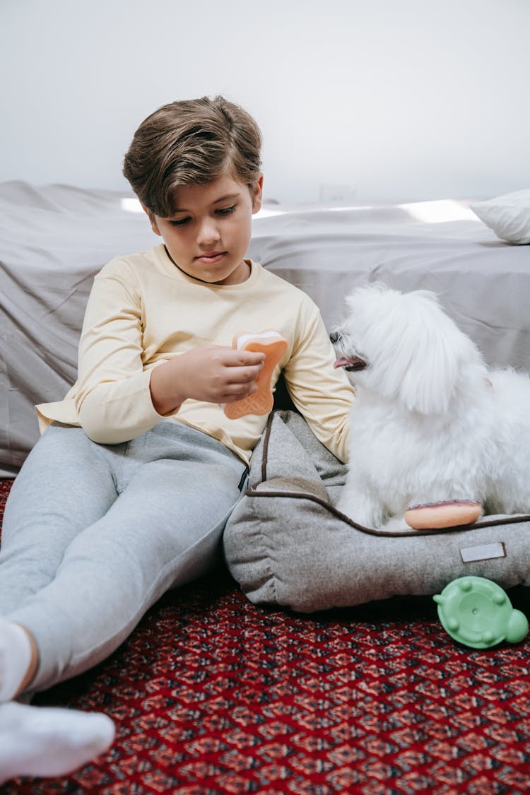 Boy And Dog Sitting Next To Bed