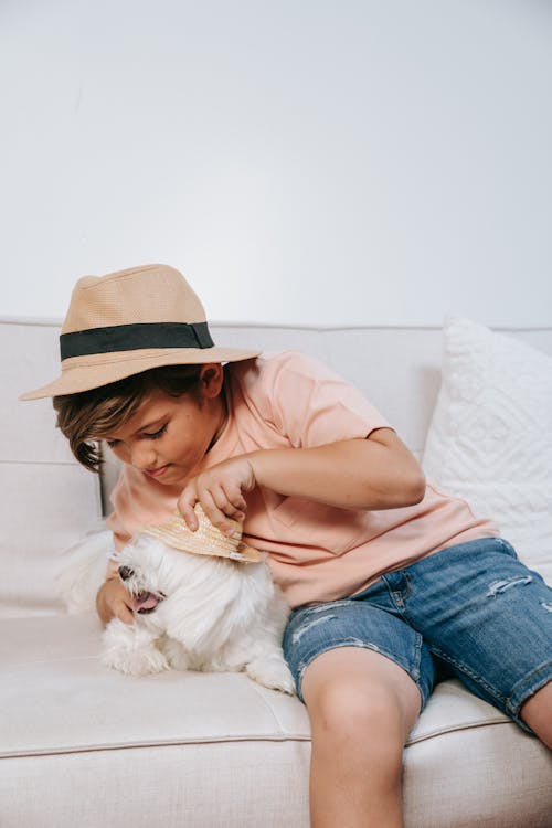 Free Woman in Brown Shirt and Blue Denim Jeans Hugging White Dog Stock Photo