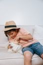 Woman in Brown Shirt and Blue Denim Jeans Hugging White Dog