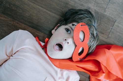 A Boy Wearing a Mask and a Cape