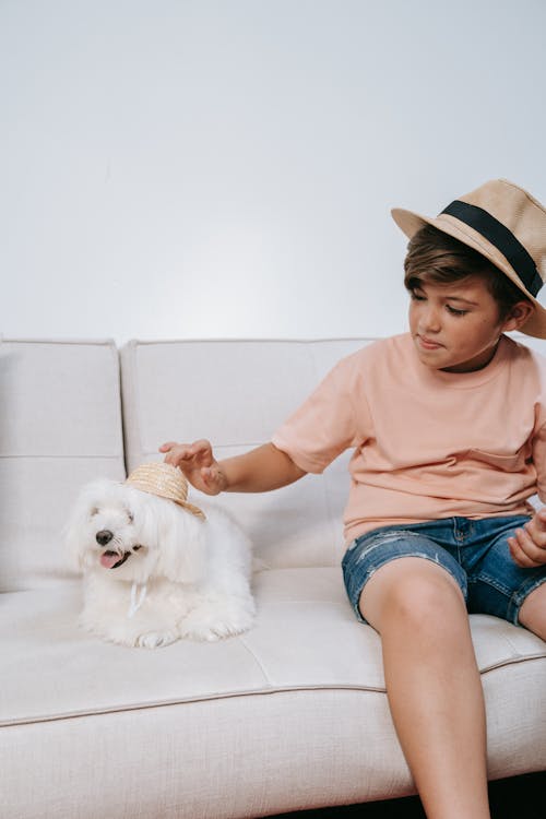Boy Sitting With His Pet Dog on a Couch
