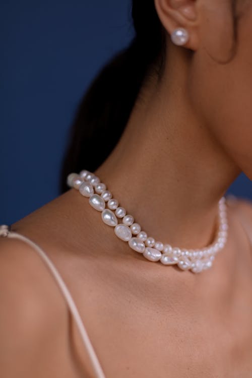 A Woman Wearing White Pearl Necklace