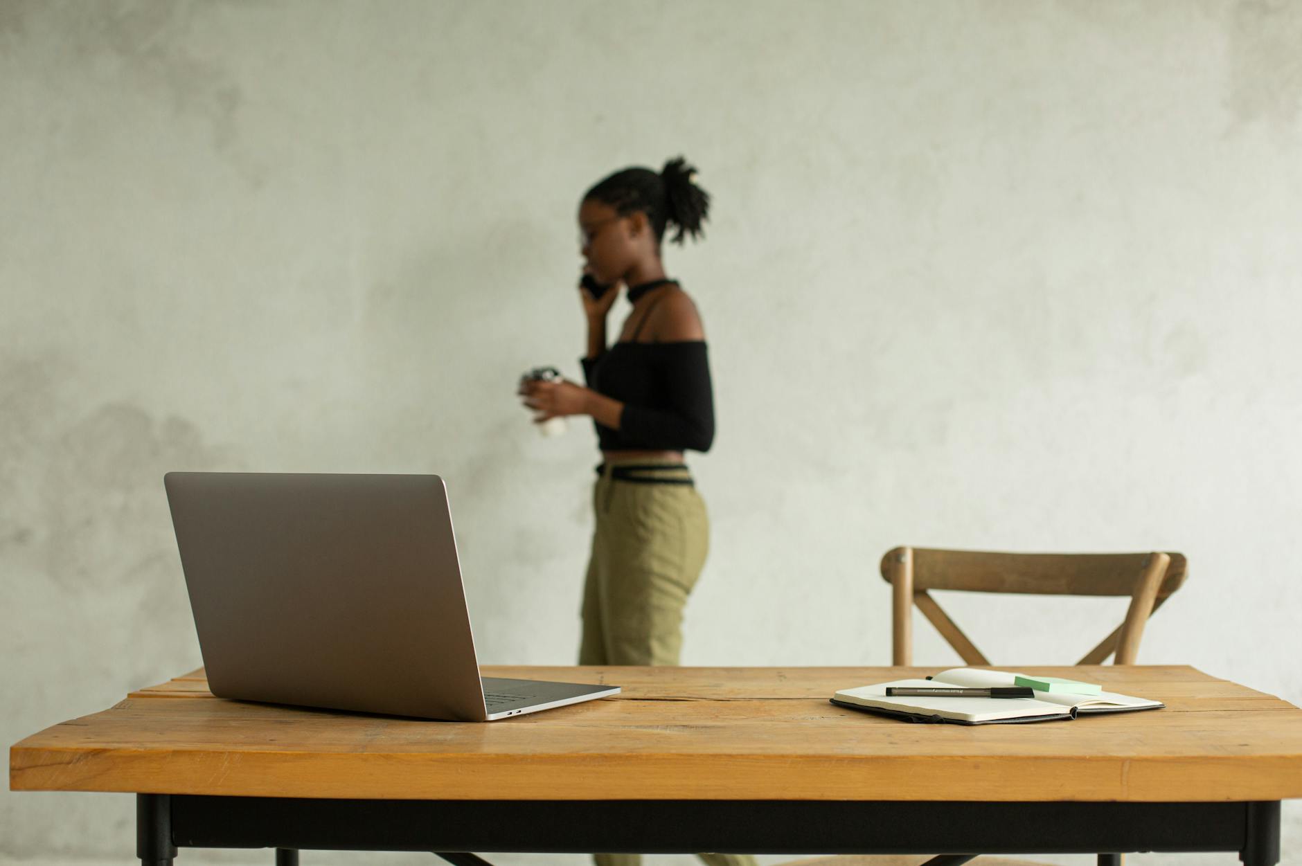 Table with Laptop and Woman on Phone