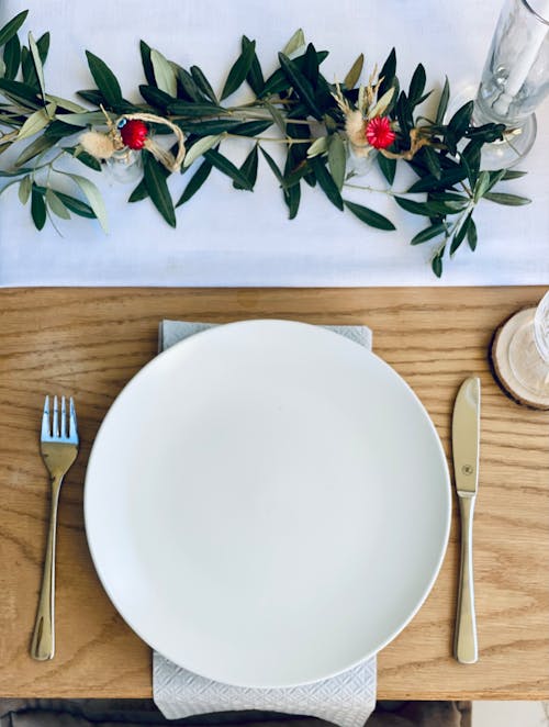 Free Cutlery on the Sides of a White Ceramic Round Plate  Stock Photo