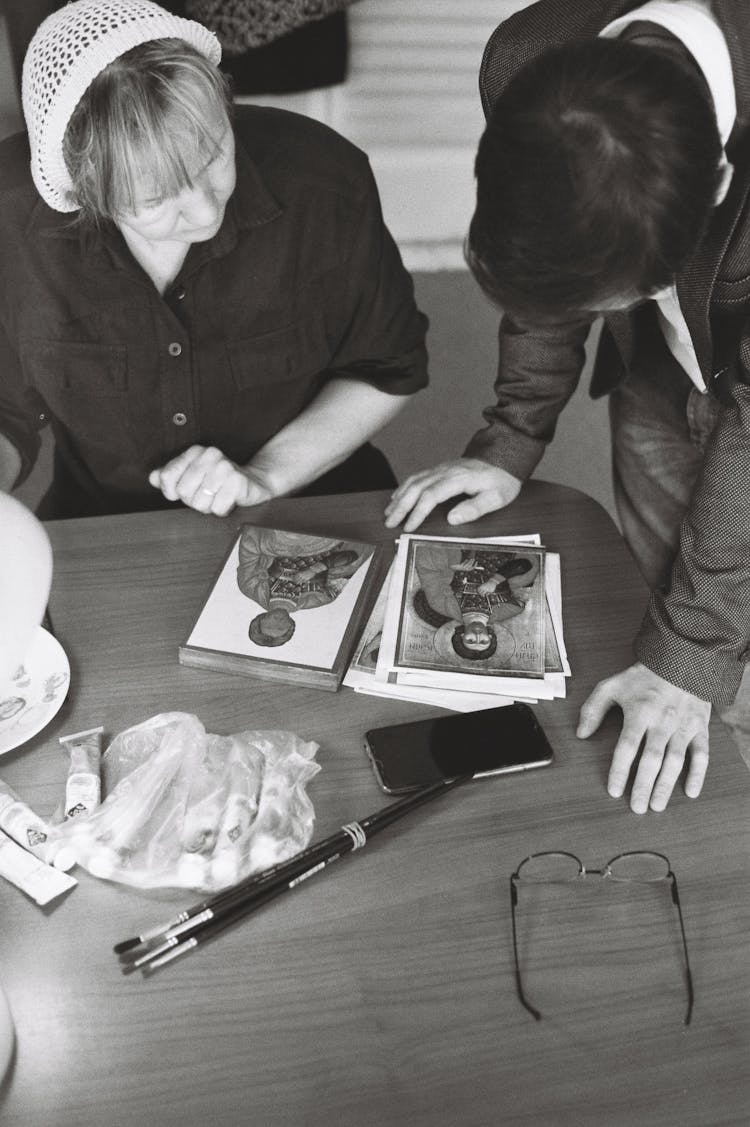 Black And White Photograph Of Experts Looking At A Religious Icon And Reproductions