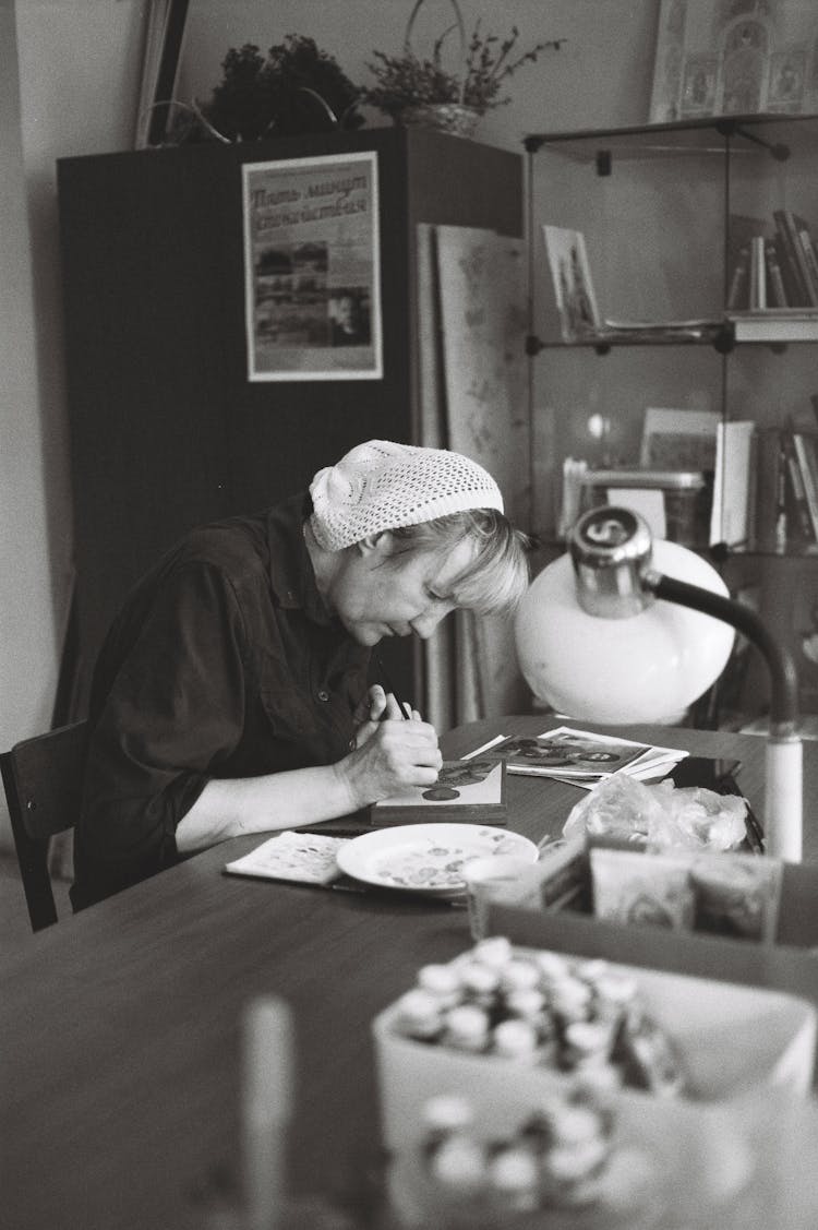 Woman Wearing White Hat Writing An Icon In A Studio