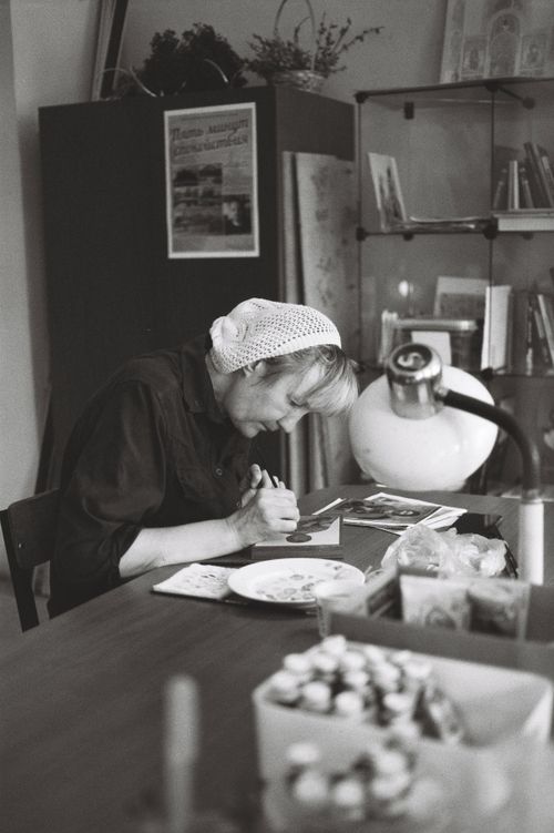 Free A focused artist working on a painting in a black and white studio setting. Stock Photo