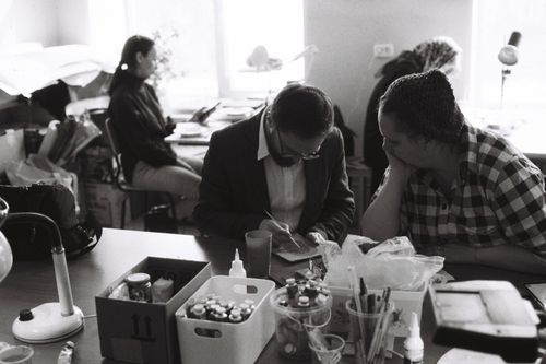 Free Artists collaborating in a studio, focusing on creative work in a dynamic environment. Stock Photo