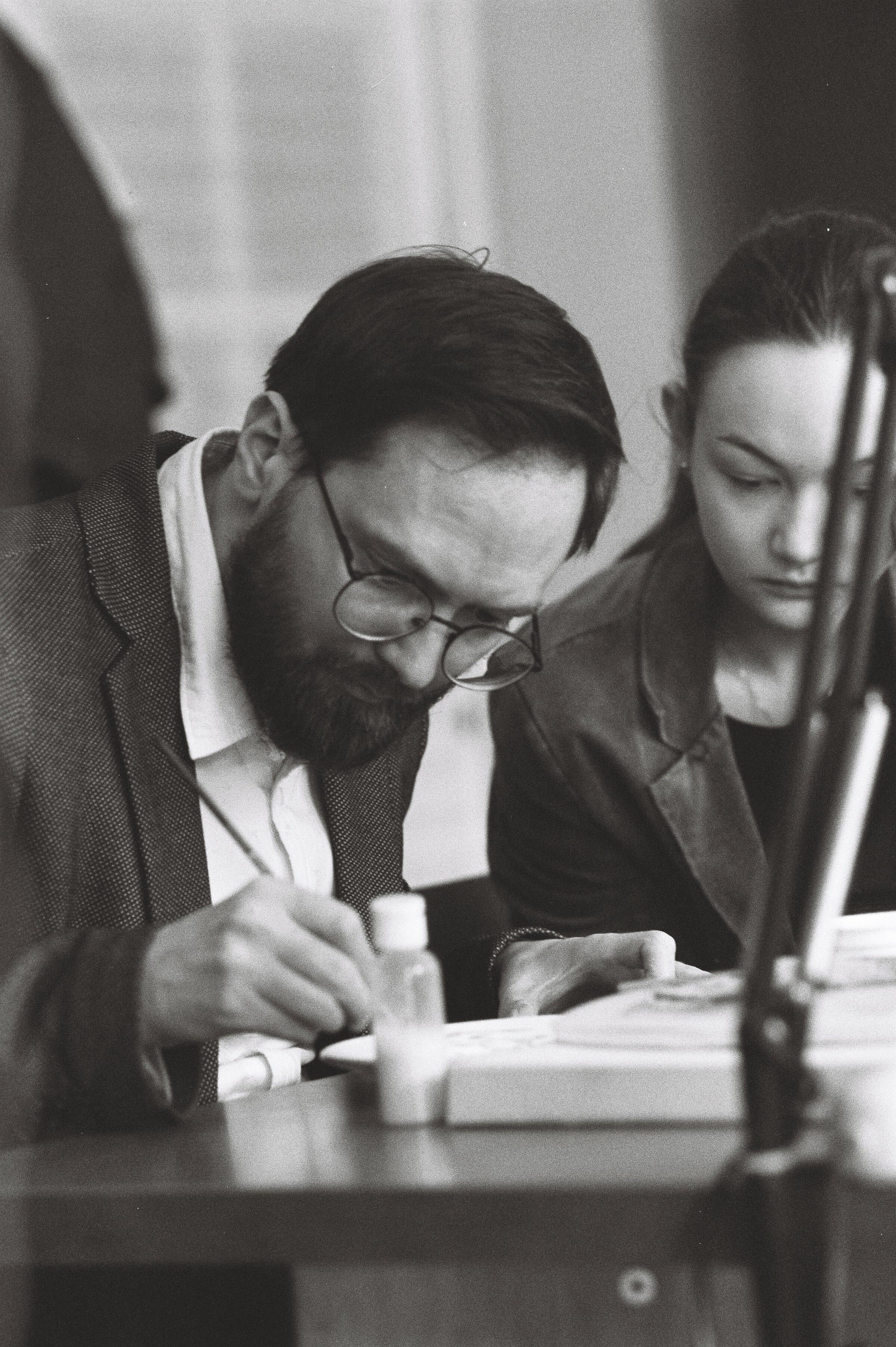 Two artists focused on their work, captured in black and white.