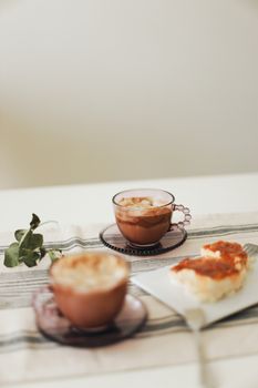 Warm, inviting breakfast scene featuring coffee and pastries on a table with a botanical touch.